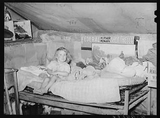 Child sitting on bed in tent home near Sallisaw,Oklahoma. Sequoyah 