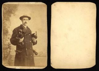 Man Holding Two Roosters Heavy Gloves in His Pocket Cabinet Photo